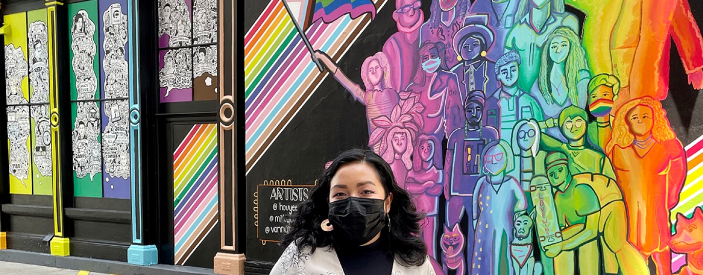 Houyee Chow stands in front of the mural she painted