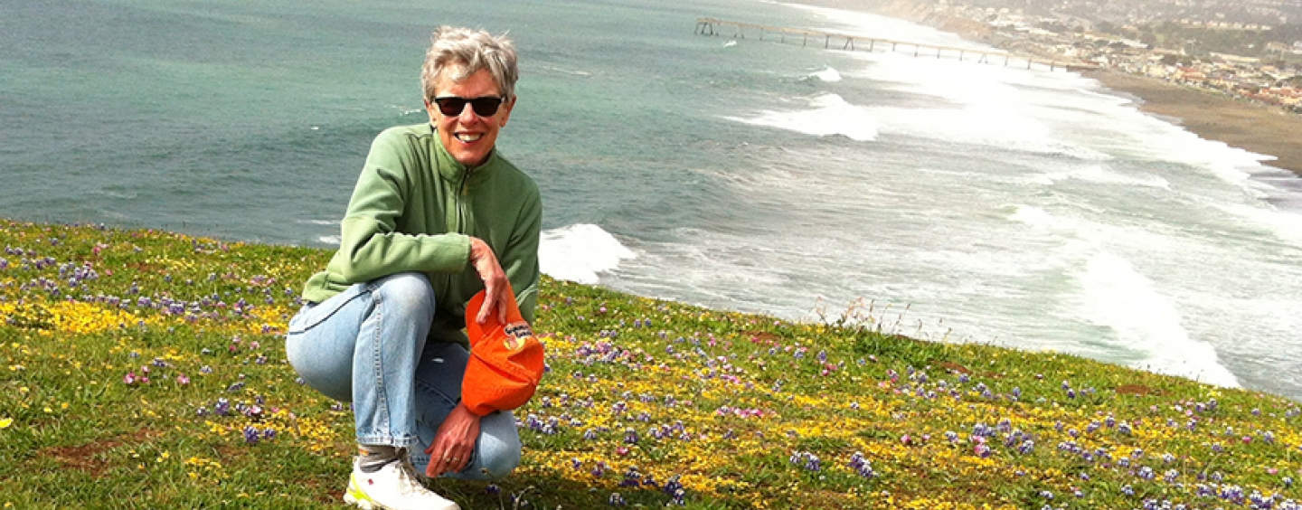 Toni Mirosevich kneels on Mori Point south of the Pacifica Municipal Pier and beach